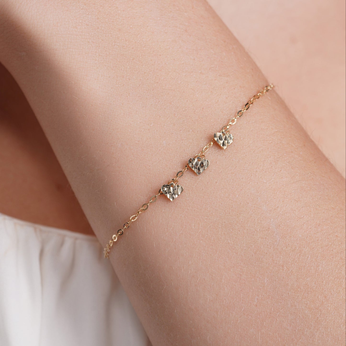 14KB0012. - 14 Karat Yellow Gold Three Diamond Cut Heart Charm Adjustable Bracelet